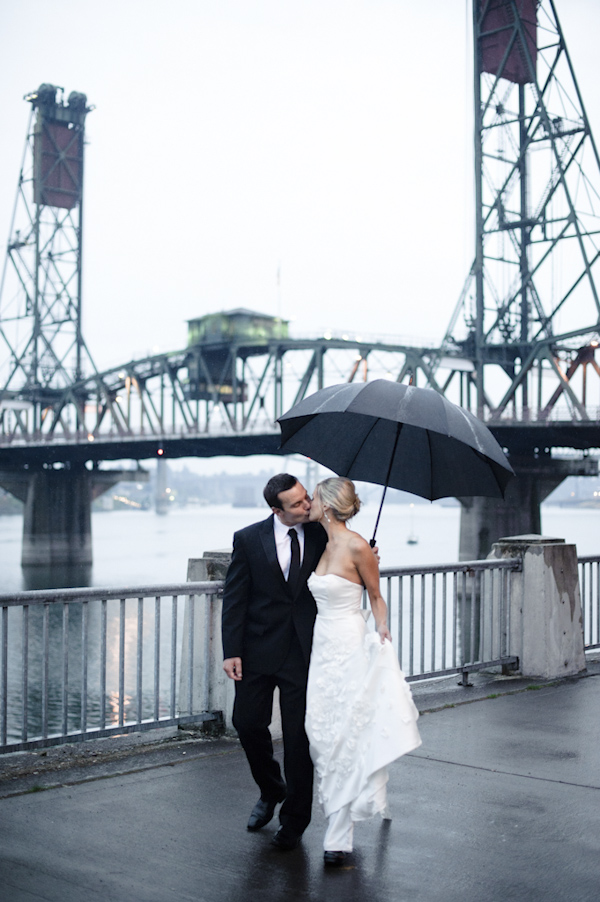 the newlywed kissing in the rain on waterfront -  wedding photo by top Portland, Oregon wedding photographer Aaron Courter